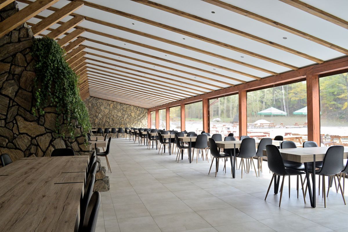 Przeszklona sala restauracyjna z widokiem na staw